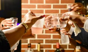 skupina ľudí si pripíja s drinkmi