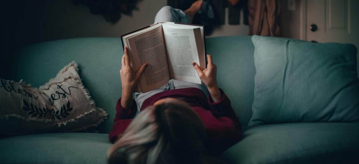dievča číta na gauči knihu