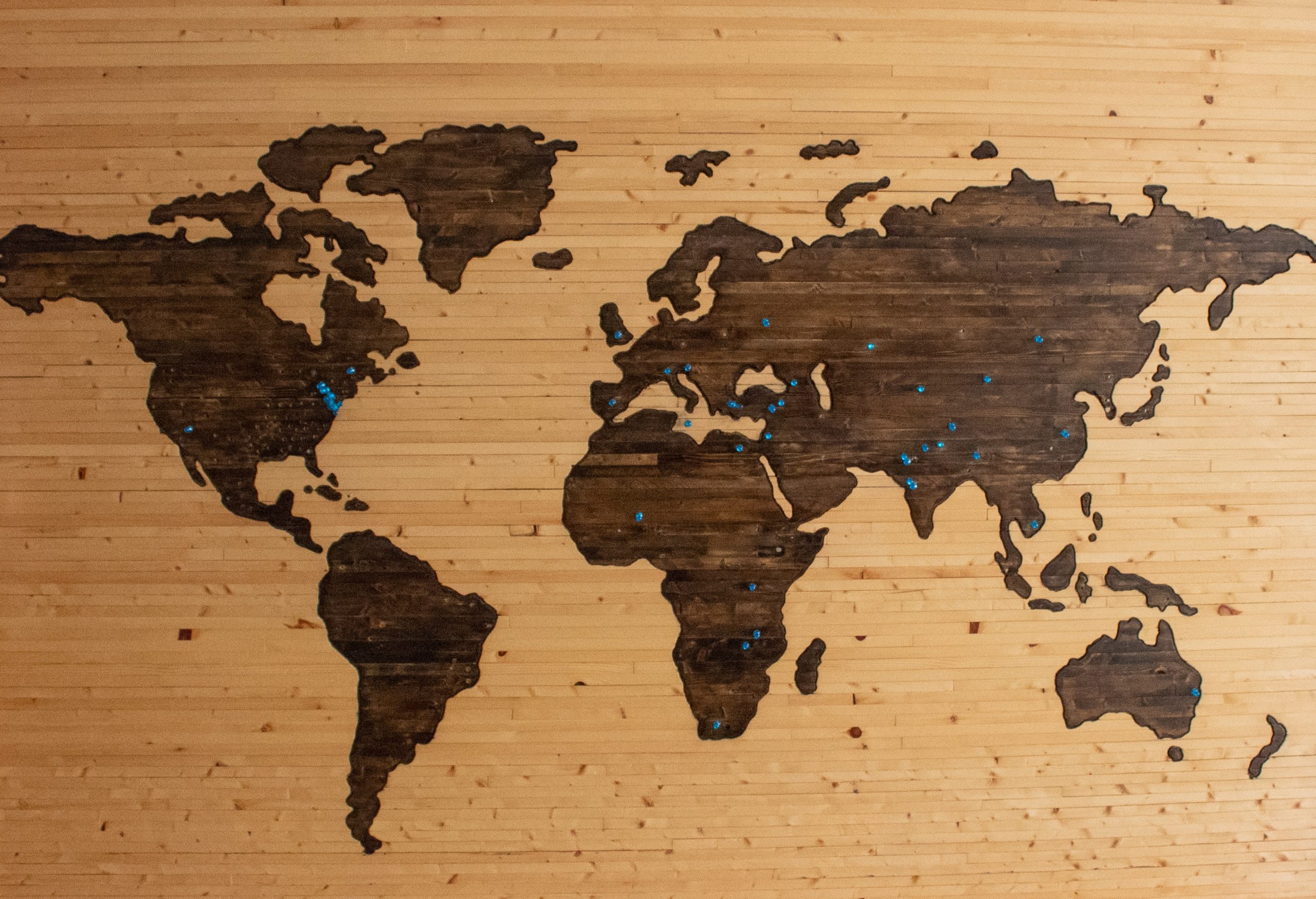 Drevená mapa sveta s pripináčikmi. 