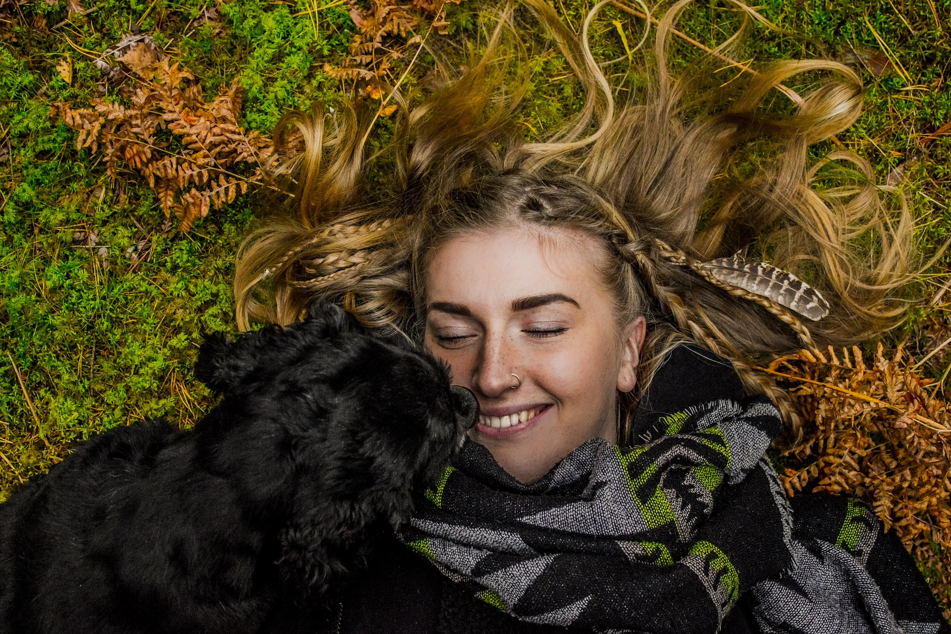 žena leží na tráve so psom