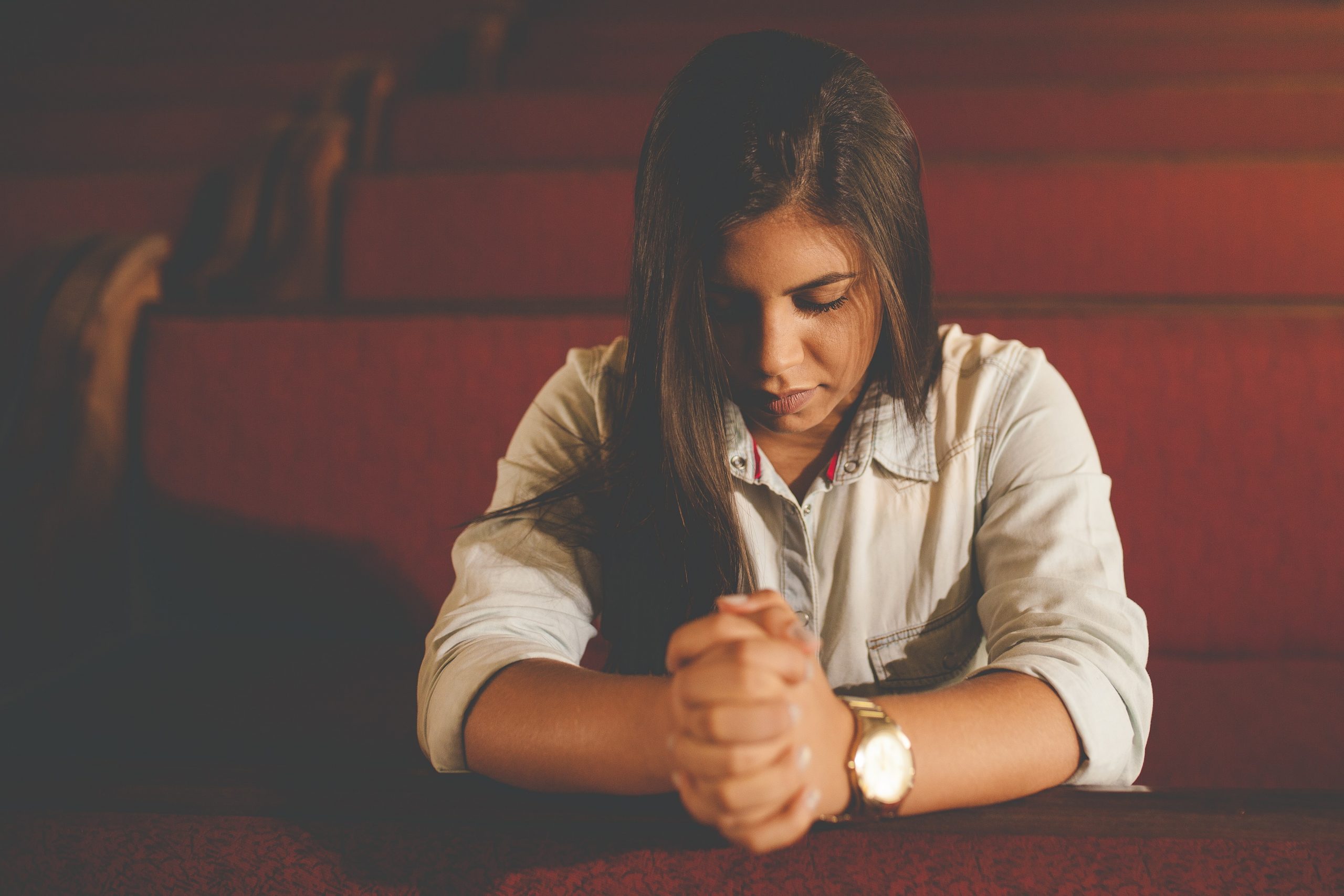 Modliaca sa žena, ktorá má evidentne veľa problémov