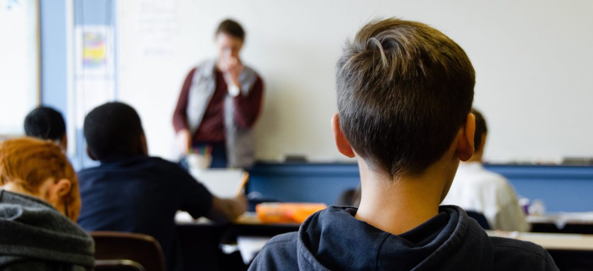 žiak sa v škole pozerá na učiteľa