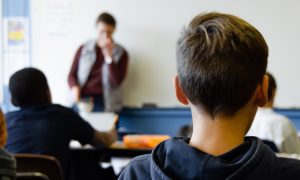 žiak sa v škole pozerá na učiteľa