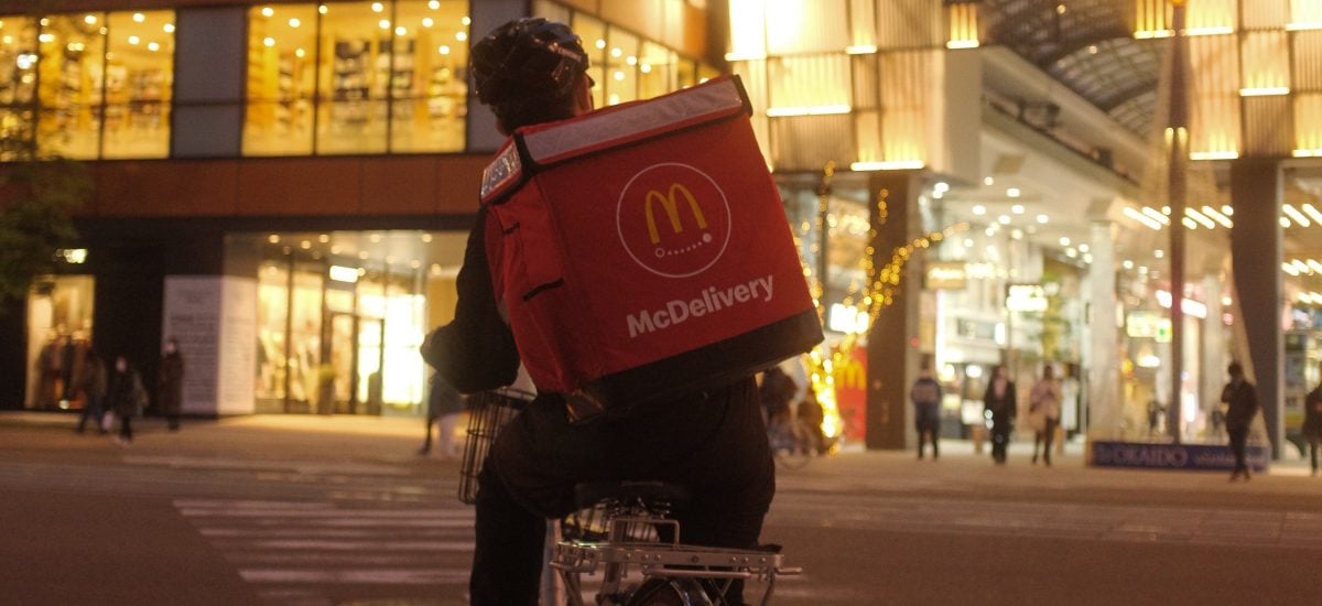 Poslíček z McDonald's Delivery na bicykli.