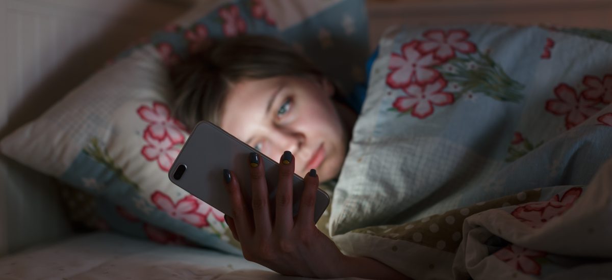 dievča sa hrá na mobile v posteli