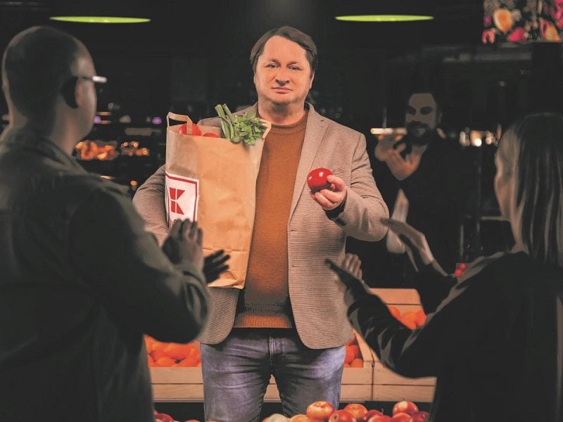 muž s jablkom a papierovou nákupnou taškou