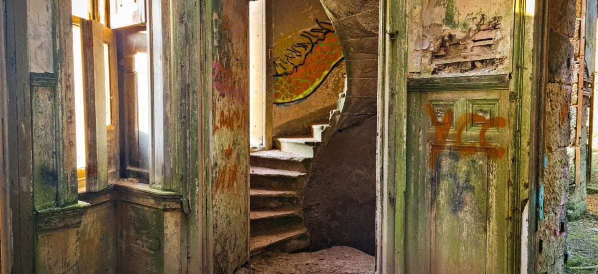 Interiér opusteného kaštieľa so schodiskom