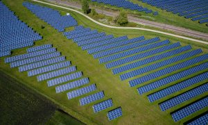 solárne panely umiestnené na rozľahlej zelenej ploche