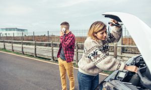 Žena a muž na diaľnici s pokazeným autom