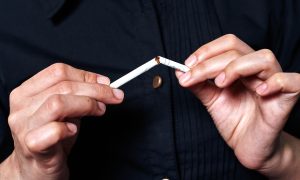 muž lámajúci cigaretu