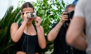 Mladý človek fotografuje moment počas výletu retro digitálnym fotoaparátom.