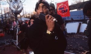 Tupac Shakur v čiernom oblečení počas nakrúcania v exteriéri